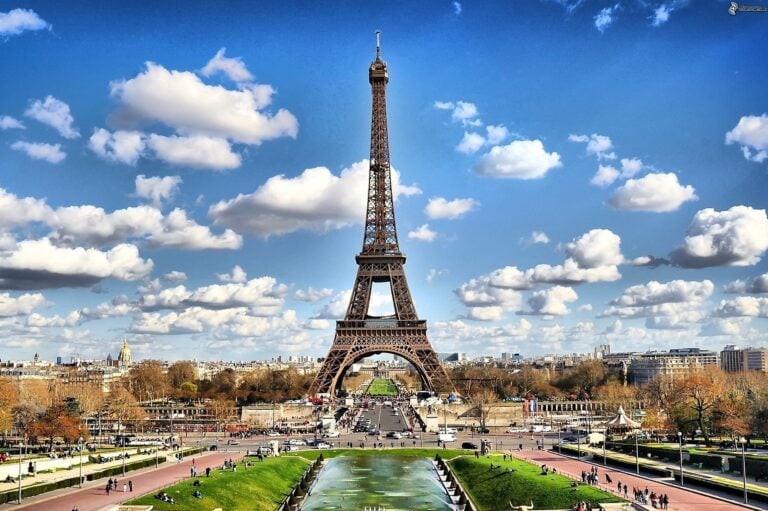 A wide angle photograph of the Eiffel Tower on a sunny day.